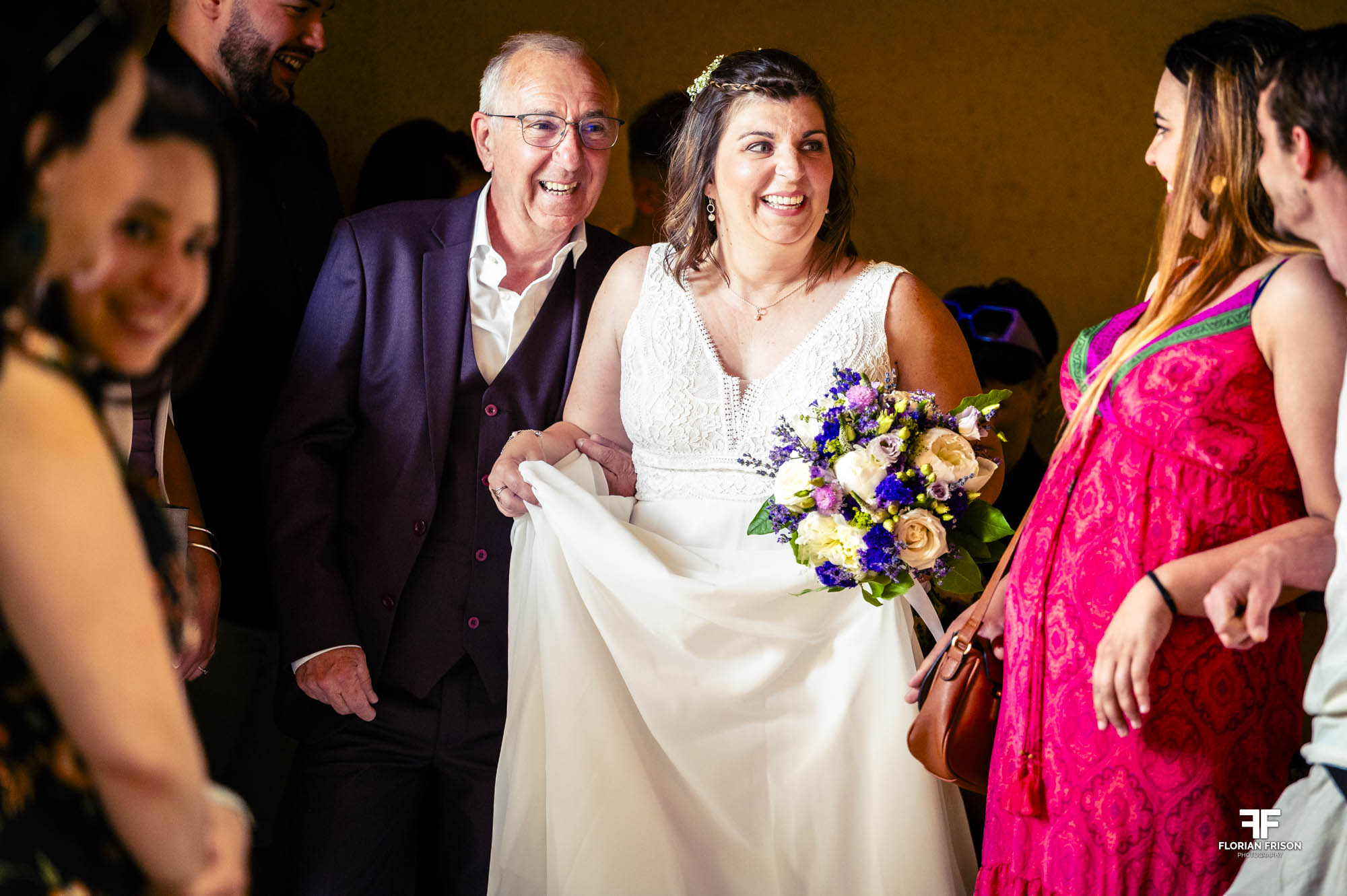Entrée rayonnante de la mariée accompagnée de son père dans la salle de réception. Un moment de joie pure lors d'un mariage authentique dans le Gard, près de Nîmes.