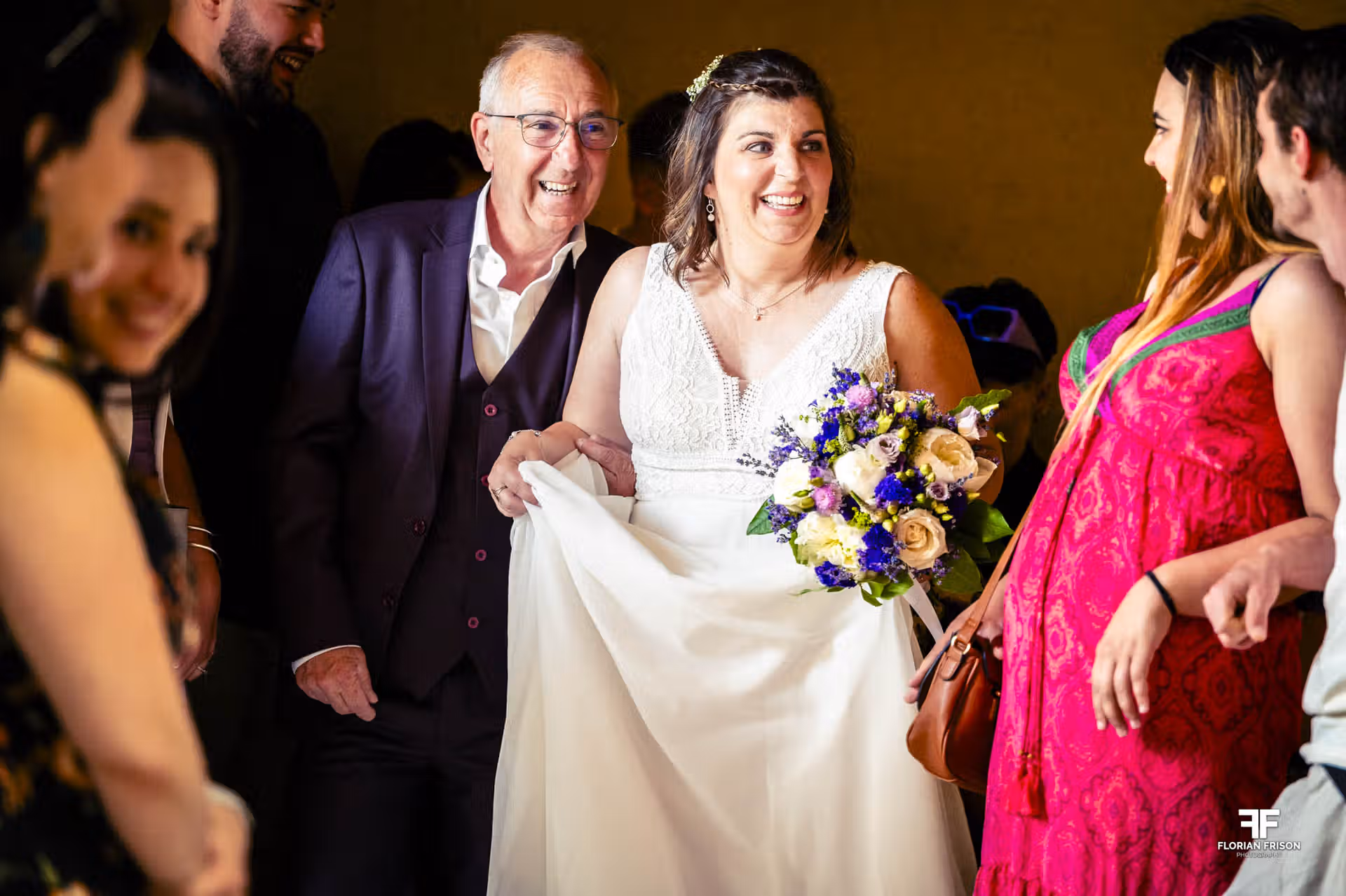 Entrée rayonnante de la mariée accompagnée de son père dans la salle de réception. Un moment de joie pure lors d'un mariage authentique dans le Gard, près de Nîmes.