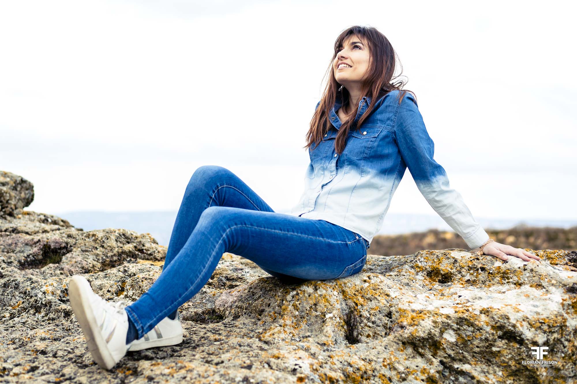 Portrait lifestyle naturel d'une jeune femme assise sur les rochers du plateau de Vernègues, près de Salon-de-Provence.