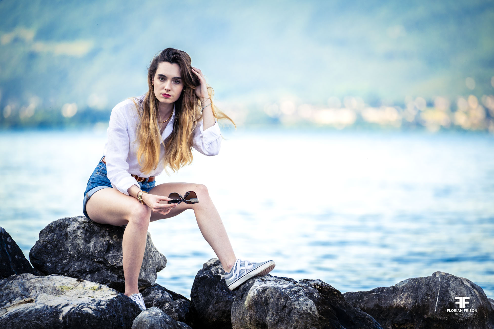 Portrait naturel et détendu d'une femme en bord de lac, lumière douce.