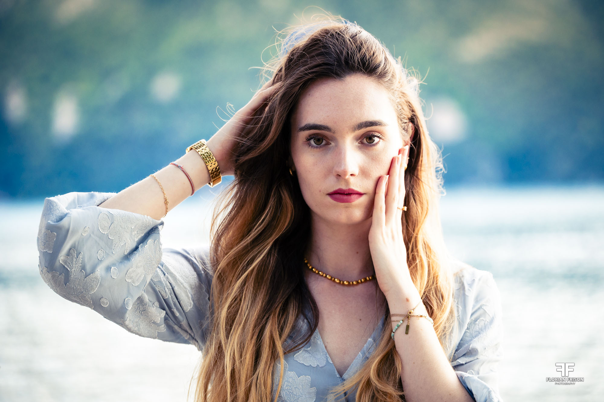 Portrait naturel et détendu d'une femme en bord de lac, lumière douce.