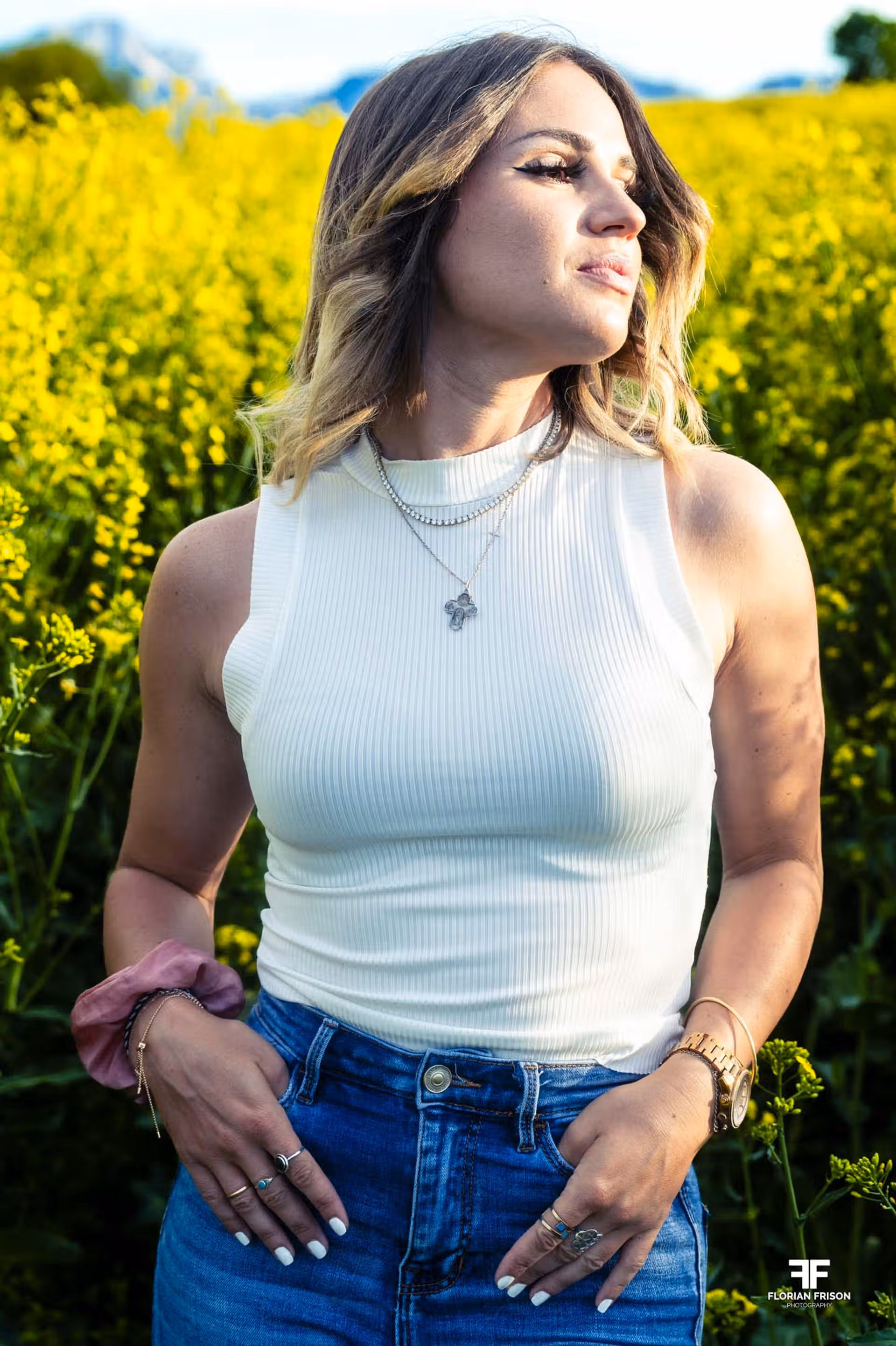 Portrait femme souriante dans un champ de colza sur les hauteurs de Chambéry en Savoie.