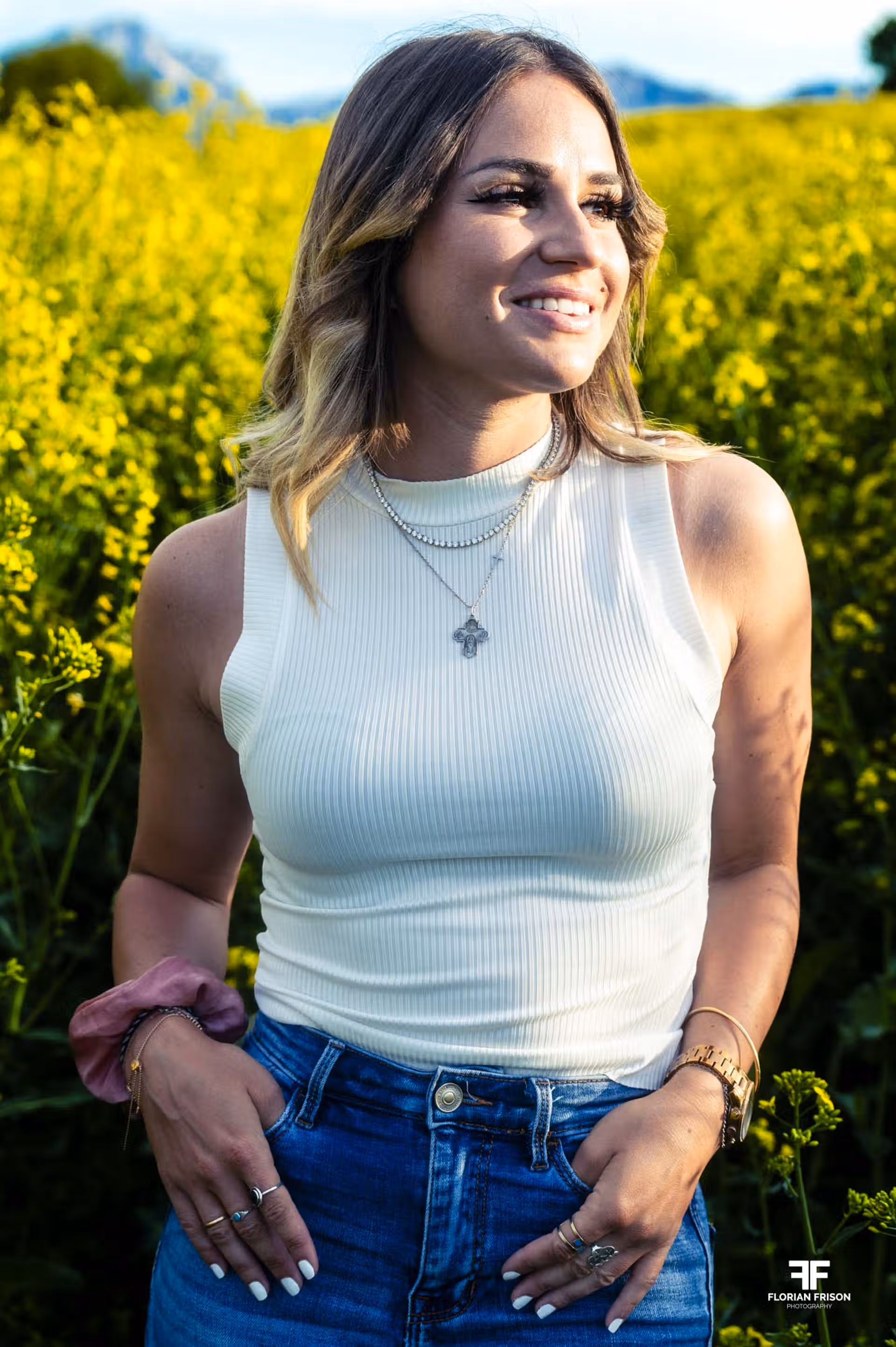 Portrait femme souriante dans un champ de colza sur les hauteurs de Chambéry en Savoie.